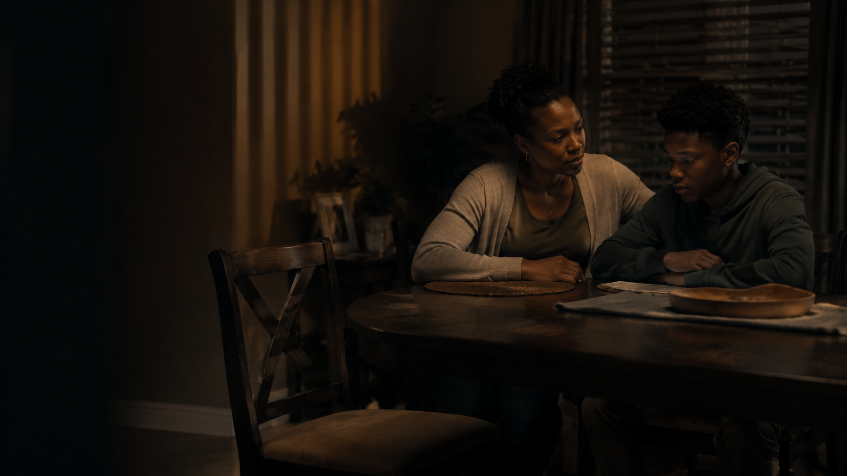 A mother and son at a family table beside an empty chair